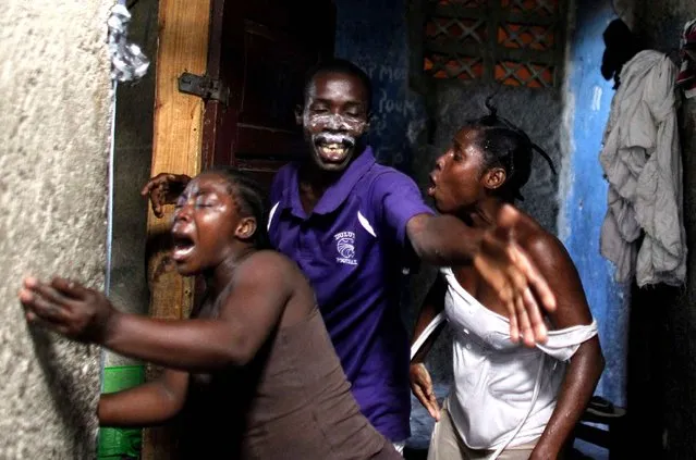 People react to tear gas fired by police during a protest near their home of supporters of presidential candidate Maryse Narcisse from Fanmi Lavalas political party in Port-au-Prince, Haiti, Tuesday, November 22, 2016. For a second straight day, partisans with a Haitian political faction hurled rocks at police and burned tires to demand “fair” election results they insist will put their candidate in the presidency. (Photo by Ricardo Arduengo/AP Photo)