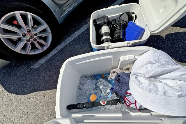 Cameras, towels and water on ice are are shown, Friday, July 21, 2023, in Phoenix. Phoenix Associated Press photographers keep their equipment on ice in their vehicles when covering extreme heat to stop the devices from overheating. (Photo by Matt York/AP Photo)