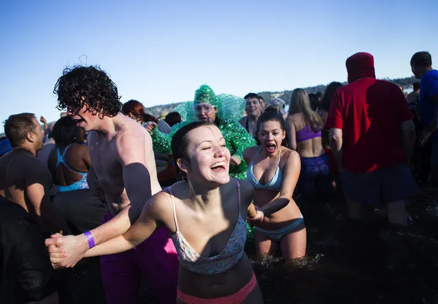 A group of friends runs back to the beach after running into the waters of Lake Washington for the 14th annual Polar Bear Plunge at Matthews Beach Park in Seattle on New Year's Day, Friday, January 1, 2016. Hundreds of participants took the plunge into an estimated 48-degree Lake Washington, while air temperatures hovered at about 40 degrees during the noontime event. (Photo by Lindsey Wasson/The Seattle Times)