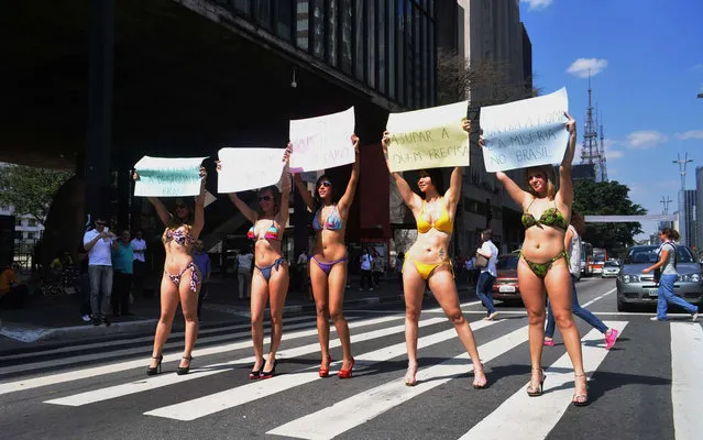 Five women wearing bikinis held a protest on August 23, 2013. The demonstration took place in the span MASP (Art Museum of São Paulo), in Paulista Avenue, in São Paulo. In one of the plates was written: “Let's end poverty and inequality in Brazil”. (Photo by J. Duran Machfee/Futura Press/Estadão Conteúdo)