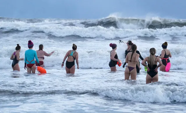 A group of women swimmers brave the freezing conditions as they gather to celebrate International Women's Day at King Edward's Bay, near Tynemouth on the North East coast of England on Wednesday, March 8, 2023. (Photo by Owen Humphreys/PA Images via Getty Images)