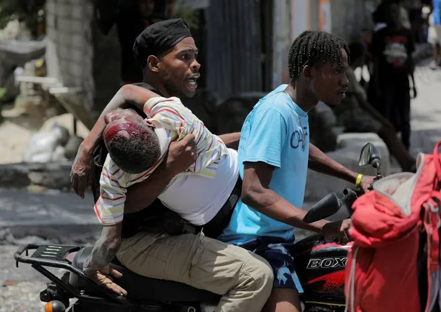 People take a wounded man to a hospital after gangs took over their neighbourhood Carrefour Feuilles, in Port-au-Prince, Haiti on August 15, 2023. (Photo by Ralph Tedy Erol/Reuters)