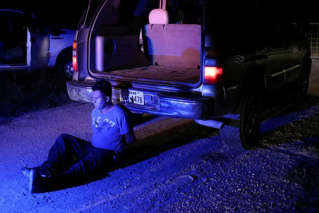 An undocumented man from Mexico is apprehended by Border Patrol agents after allegedly dropping off a group of migrants in an area known for human smuggling near Falfurrias, Texas on August 18, 2018. (Photo by Loren Elliott/Reuters)