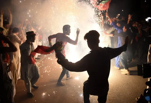 Supporters of Pakistan's cricketer-turned politician Imran Khan, and head of the Pakistan Tehreek-e-Insaf (Movement for Justice) party, celebrate in Karachi on July 26, 2018, a day after a general election. Pakistan cricket hero turned politician Imran Khan has claimed victory on July 26, in the country's tense general election marred by allegations of “blatant” rigging by rival parties. A visibly tired Khan cut a conciliatory tone in a wide-ranging address to the nation following a controversial contest hit by accusations from major political parties of poll rigging and long delays in still unreleased official results. (Photo by Rizwan Tabassum/AFP Photo)