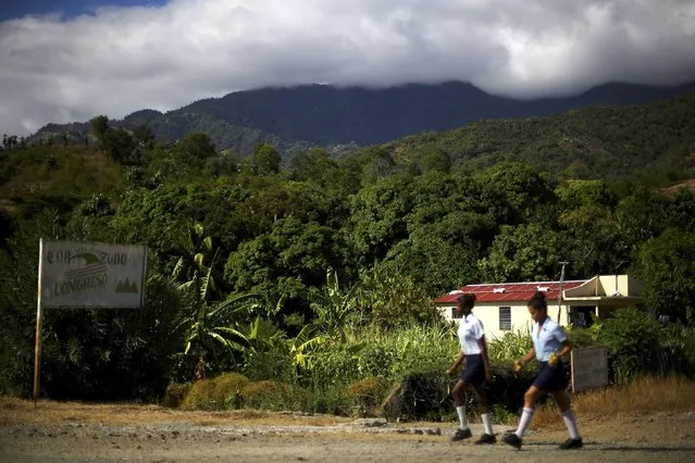 Students walk down a road along Cuba's southern coast and in the foothills of the Sierra Maestra mountains, where President Fidel Castro launched his armed revolution in 1956, as the area prepares for tomorrow's arrival of the caravan carrying Castro's ashes, on the outskirts of Santiago de Cuba, Cuba, December 2, 2016. (Photo by Ivan Alvarado/Reuters)