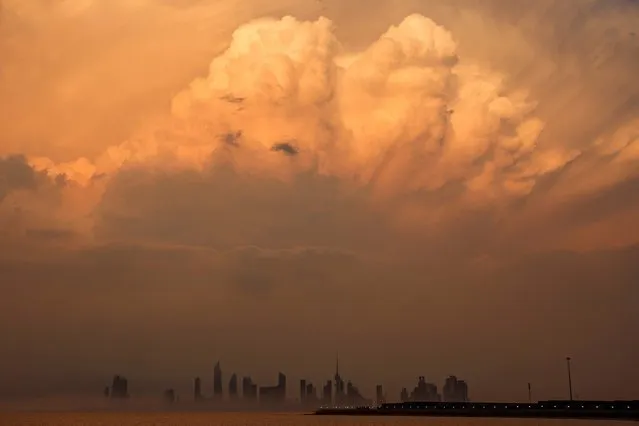 This picture taken on March 15, 2023 shows a view of clouds covering the skyline of Kuwait City at sunset. (Photo by Yasser Al-Zayyat/AFP Photo)