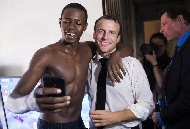 French President Emmanuel Macron poses for a selfie with a youth in the Quartier Orleans during a visit to the French Caribbean island of Saint-Martin, September 29, 2018. (Photo by Eliot Blondet/Pool via Reuters)