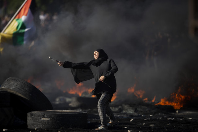 Palestinians clash with Israeli forces at the Hawara checkpoint, south of the West Bank city of Nablus, Tuesday, May 18, 2021. (Photo by Majdi Mohammed/AP Photo)