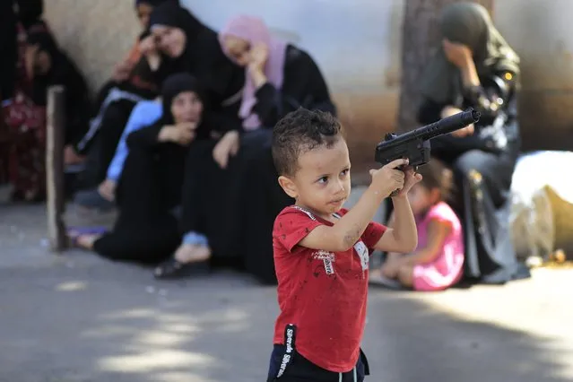 A Palestinian boy holds a toy gun who fled his home with his family to a mosque after clashes that erupted between members of the Palestinian Fatah group and Islamist militants in the Palestinian refugee camp of Ein el-Hilweh near the southern port city of Sidon, Friday, September 8, 2023. (Photo by Mohammed Zaatari/AP Photo)