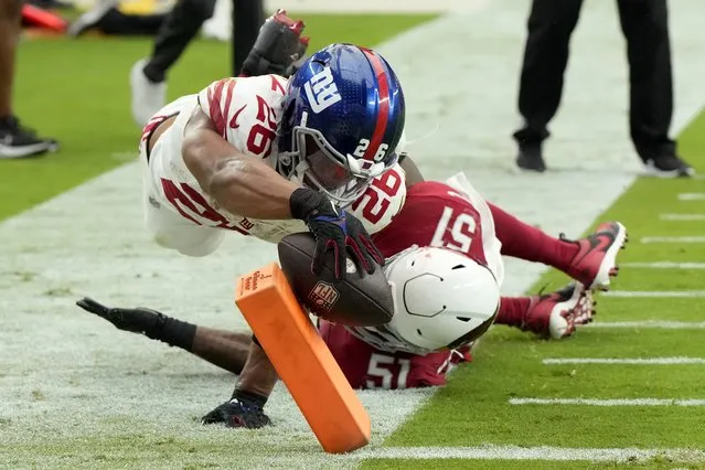 New York Giants running back Saquon Barkley (26) dives into the end zone for a touchdown as Arizona Cardinals linebacker Krys Barnes (51) defends during the second half of an NFL football game, Sunday, September 17, 2023, in Glendale, Ariz. (Photo by Rick Scuteri/AP Photo)