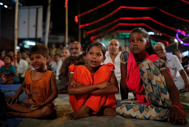 Children sit at the roadside as they watch Ramlila, a re-enactment of the life of Hindu Lord Rama, during Vijaya Dashmi or Dussehra festival celebrations in Mumbai, India, October 16, 2018. (Photo by Danish Siddiqui/Reuters)