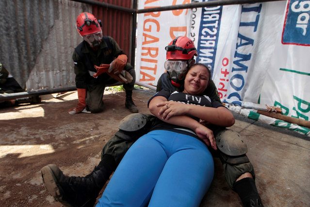 A member of Nicaragua's army carries a participant role-playing as an injured person during a national multi-hazard drill in Managua, Nicaragua December 20, 2016. (Photo by Oswaldo Rivas/Reuters)