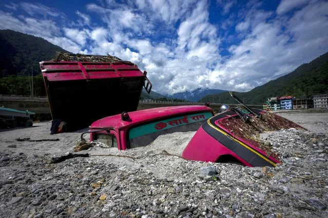 Vehicles lie submerged in mud in the flood affected area along the Teesta river in Rongpo, east Sikkim, India, Sunday, October. 8. 2023. (Photo by Anupam Nath/AP Photo)