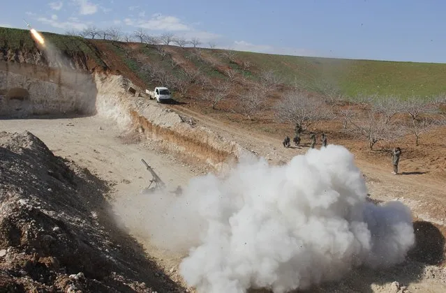 Rebel fighters fire Grad rockets toward forces of Syria's President Bashar al-Assad stationed in al-Suqaylabiyah district, from the orchards north of Kfar Zeita village in the northern countryside of Hama January 29, 2015. (Photo by Mohamad Bayoush/Reuters)