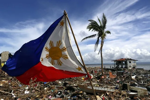 The Philippines flag is blown by the wind in a super devastated view of Tacloban City, Leyte province, Philippines, 13 November 2013. (Photo by Mast Irham/EPA)