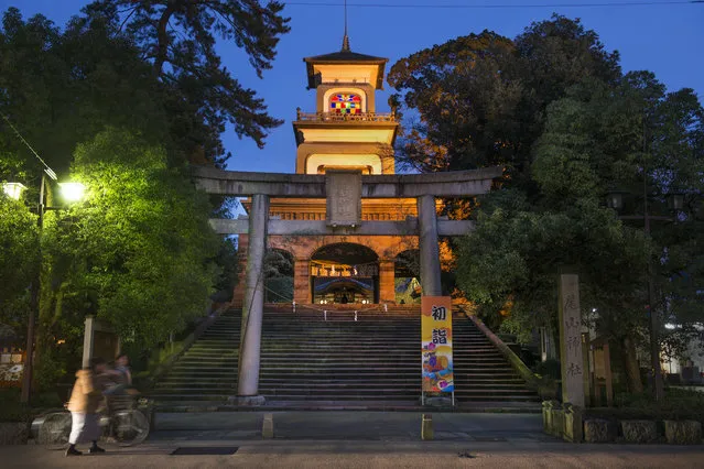 Amidst the hustle and bustle of city life, the main gate to the Oyama Jinja shrine stands tall in Kanazawa, Japan on January 12, 2016.  The shrine (not pictured) was established in 1599 in Utatsuyama and moved to its present location in 1873 and renamed to Oyama-jinja. The main gate was constructed in 1875. This gate is a peculiar mix of traditional Japanese, Chinese, and European religious architectural elements. The gate is 25 metres (82 ft) high including the lightning rod. (Photo by Linda Davidson/The Washington Post)