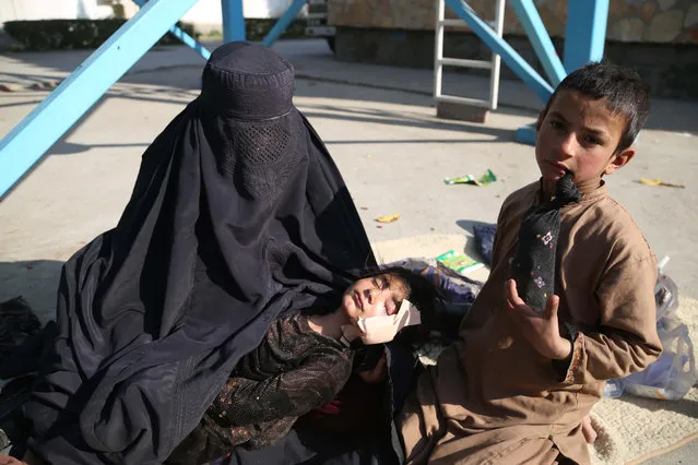A mother holds her daughter who was injured in an airstrike in Kunar province, as she receives medical treatment at a hospital in Jalalabad, Afghanistan, 16 December 2018. According to reports, at least 20 Afghan civilians, including 12 children, were killed in an airstrike targeting a Taliban commander in the eastern province of Kunar. (Photo by Ghulamullah Habibi/EPA/EFE)