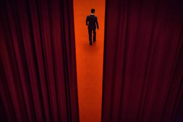 In this Thursday, March 8, 2018 photo, a security official walks through a curtained-off area during a plenary session of the Chinese People's Political Consultative Conference (CPPCC) at the Great Hall of the People in Beijing. The annual conclave of China's National People's Congress is a carefully scripted affair, but the actual decision-making happens out of sight and away from prying eyes. (Photo bt Mark Schiefelbein/AP Photo)