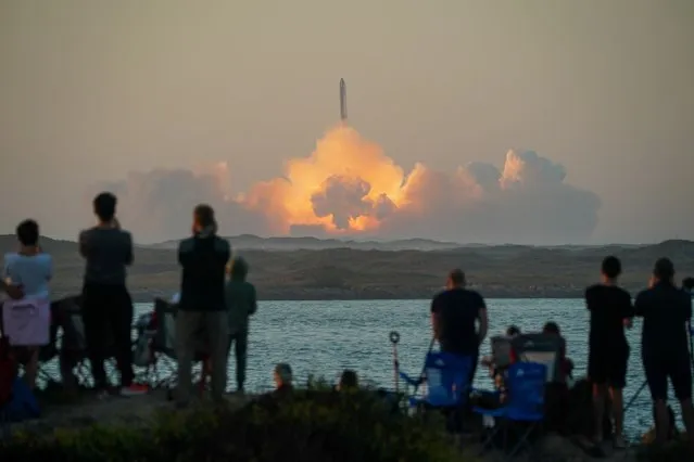 People watch as SpaceX's next-generation Starship spacecraft atop its powerful Super Heavy rocket lifts off from the company's Boca Chica launchpad on an uncrewed test flight, as seen from South Padre Island, near Brownsville, Texas, U.S. November 18, 2023. (Photo by Go Nakamura/Reuters)