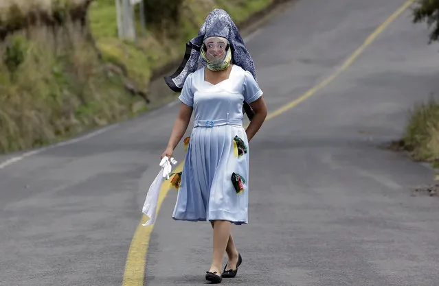 A woman dressed for la “La Diablada” festival, walks down a road in Pillaro, Ecuador, Friday, January 6, 2017. Local legend holds that anyone who adopts a costume for the celebration and wears it at the event six years in a row will have good luckDolores Ochoa