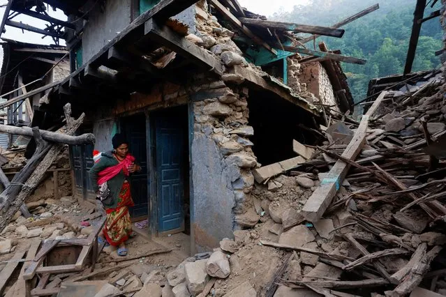 A woman stands in front of her collapsed house after an earthquake in Jajarkot, Nepal on November 6, 2023. (Photo by Navesh Chitrakar/Reuters)