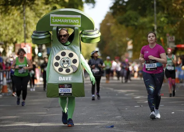 Some runners seen in fancy costumes as they run past mile 21 during the London marathon on October 2, 2022. Marathon runners passed two stages with music and drag performances. (Photo by John Sibley/Action Images via Reuters)