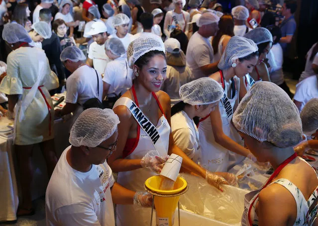 Miss Universe contestant Jihan Dimack of Tanzania joins other contestants in packing meals for distribution to the needy in suburban Pasay city southeast of Manila, Philippines Wednesday, January 18, 2017. (Photo by Bullit Marquez/AP Photo)
