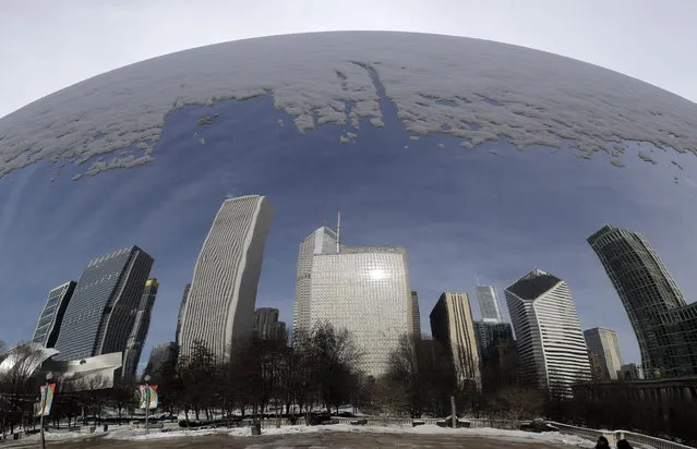 Reflections of a snowy city are seen in the 110-ton stainless steel Anish Kapoor sculpture called “Cloud Gate” and nicknamed “The Bean” at Millennium Park in Chicago, Sunday, January 27, 2019. More than with many snowstorms Chicagoans have endured in recent history, where you live will greatly impact how much snow you arise to Monday morning, forecasters said. (Photo by Nam Y. Huh/AP Photo)