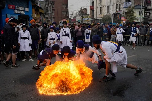 Indian Sikh warriors display martial arts skills in a religious procession ahead of the birth anniversary of Guru Gobind Singh in Jammu, India, Wednesday, January 3, 2024. The birth anniversary of Guru Gobind Singh, the tenth Sikh guru, will be marked on Jan.5. (Photo by Channi Anand/AP Photo)