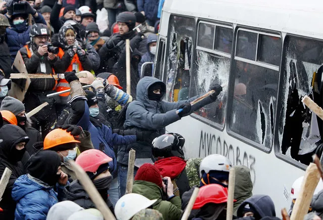 Pro-European protesters attack a police van during a rally near government administration buildings in Kiev January 19, 2014. Up to 100,000 Ukrainians massed in the capital Kiev on Sunday in defiance of sweeping new laws aimed at stamping out anti-government protests. The rally, the biggest this year in a cycle of pro-Europe protests convulsing the former Soviet republic for the past two months, was spurred by the legislation rushed through parliament last week and which the opposition says will lead to a police state. (Photo by Gleb Garanich/Reuters)
