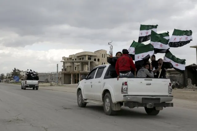Protesters carry Free Syrian Army flags while riding pick-up trucks during an anti-government protest in the town of Marat Numan in Idlib province, Syria March 4, 2016. (Photo by Khalil Ashawi/Reuters)