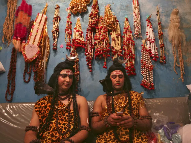 Artists dressed as Lord Shiva read a message on a mobile phone as they prepare to participate in a religious procession ahead of the Mahashivratri festival in Jammu March 9, 2013. (Photo by Mukesh Gupta/Reuters)