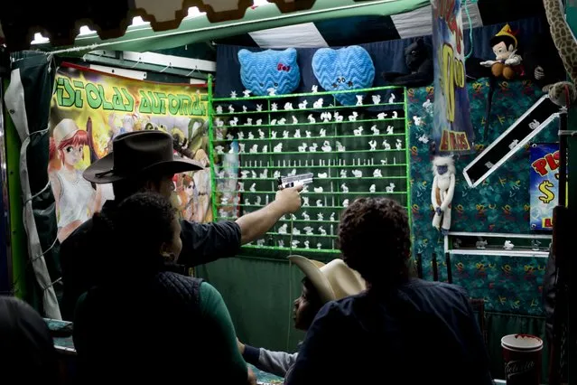 In this April 11, 2015 photo, a man plays a shooting game for 10 pesos (about .65 cents) at the Texcoco Fair on the outskirts of Mexico City. This game doesn't give out prizes to the winners. Prize-giving games are 20 pesos or more. (Photo by Eduardo Verdugo/AP Photo)