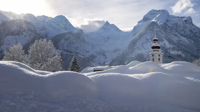 The steeple of the Loferer church is seen through the snow in Lofer, Austrian province of Salzburg on Friday, January 11, 2019 after a heavy snowfall. (Photo by Kerstin Joensson/AP Photo)