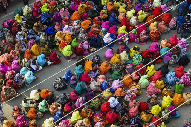 Bangladeshi garment workers block a road during a demonstration to demand higher wages, in Dhaka on January 9, 2019. Bangladeshi police on January 9 used water cannon to disperse 10,000 striking garment workers who were blocking a major highway in a fourth day of industrial action, an official said. (Photo by Munir Uz Zaman/AFP Photo)
