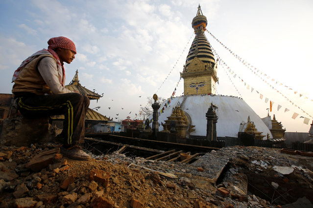 A laborer sits on top of the debris of a monastery damaged during the 2015 earthquake, in Swayambhunath Stupa, a UNESCO world heritage site in Kathmandu, Nepal January 11, 2017. (Photo by Navesh Chitrakar/Reuters)