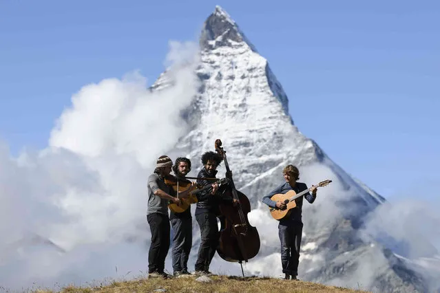Jean-Christophe Gairard, Violin, Florian Vella, Guitar, Nesar Ouaryachi, Double bass, and Gaspard Panfiloff, Guitar and Balalaika, of the French Band Tournee des Refuges, from left, play with their musical instruments in front of the Cervin (Matterhorn) Mountain after having given a concert the day before at the Monte Rosa Hut (2883m), during the Zermatt Music Festival and Academy, above Zermatt, Switzerland, on Friday 17 September 2021. (Photo by Anthony Anex/Keystone via AP Photo)