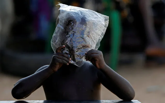 An internally displaced boy plays with a bit of plastic sheet in a United Nations Mission in South Sudan (UNMISS) Protection of Civilian site (CoP), outside the capital Juba, South Sudan, January 25, 2017. (Photo by Siegfried Modola/Reuters)