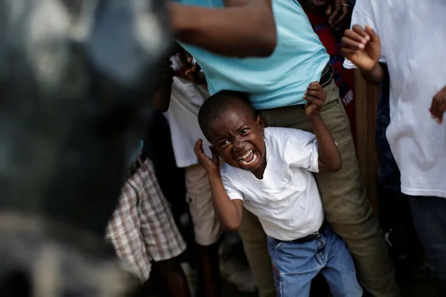 A reveller scares a boy during the Carnival parade in Jacmel, Haiti, February 19, 2017. (Photo by Andres Martinez Casares/Reuters)