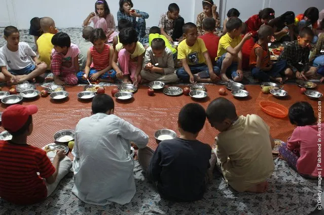 Afghan orphans eat dinner at the Satara Orphanage
