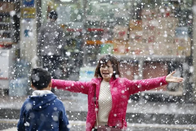 A Chinese tourist shares a moment with her child during snowfall in Seoul, South Korea, February 16, 2016. (Photo by Kim Hong-Ji/Reuters)
