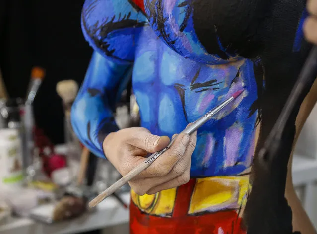 In this March 19, 2016 photo, over a 12 hour period, Kay Pike transforms herself using body paint and latex into Superman at her home in Calgary, Alberta. “At the end, it's a little sad to wash it off”, she says. (Photo by Jeff McIntosh/The Canadian Press via AP Photo)