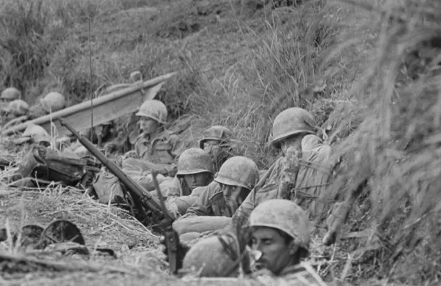 Soldiers of the Army 7th Infantry Division, crouching in a ditch nr. Rocky Crags on the first day of battle deemed one of the toughest this veteran unit had ever encountered during struggle to win the island, April 21, 1945. (Photo by W. Eugene Smith/The LIFE Picture Collection/Getty Images)