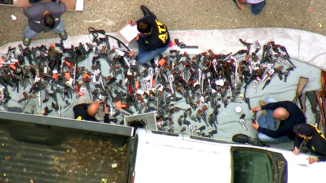 This photo from video provided by KCBS/KCAL-TV shows investigators from the U.S. Bureau of Alcohol, Tobacco, Firearms and Explosives and the police inspecting a large cache of weapons seized at a home in the affluent Holmby Hills area of Los Angeles Wednesday, May 8, 2019. Authorities seized more than a thousand guns from the home after getting an anonymous tip regarding illegal firearms sales in a posh area near the Playboy Mansion and served a search warrant around 4 a.m. Wednesday at the property on the border of the Bel Air and Holmby Hills neighborhoods. (Photo by KCBS/KCAL-TV via AP Photo)