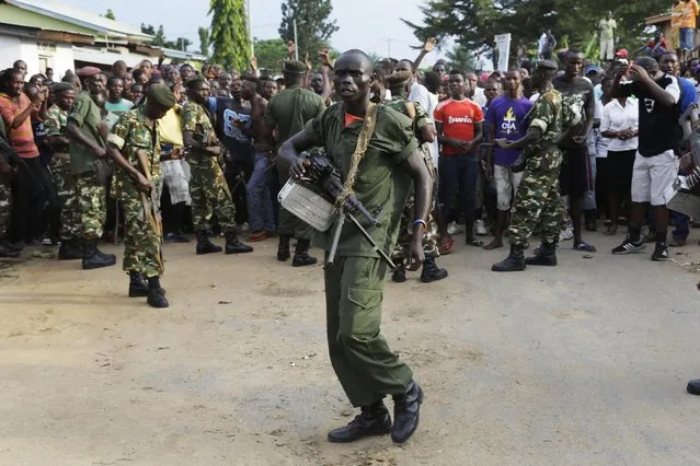 Soldiers attempt to stop a group of demonstrators running towards a cordon of police in the Musaga neighborhood of Bujumbura, Burundi, Wednesday May 20, 2015. (Photo by Jerome Delay/AP Photo)