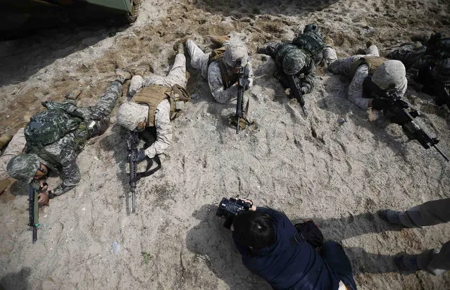 A journalist films as U.S. and South Korean marines participate in a U.S.-South Korea joint landing operation drill in Pohang March 31, 2014. (Photo by Kim Hong-Ji/Reuters)