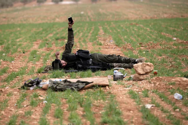 A rebel fighter rests on the ground east of al-Bab town, Syria March 9, 2017. (Photo by Khalil Ashawi/Reuters)