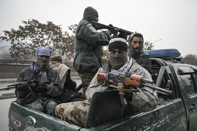 Taliban fighters patrol along a street during a demonstration by people to condemn the recent protest by the Afghan women's rights activists, in Kabul on January 21, 2022. (Photo by Mohd Rasfan/AFP Photo)