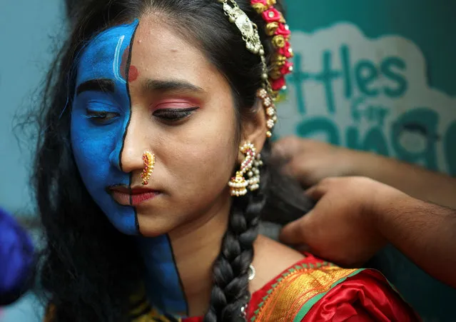 A student gets her make-up done before taking part in a cultural event to mark the Hindu festival of Janmashtami, or the birth anniversary of Hindu Lord Krishna, inside a college in Mumbai, India, August 21, 2019. (Photo by Hemanshi Kamani/Reuters)