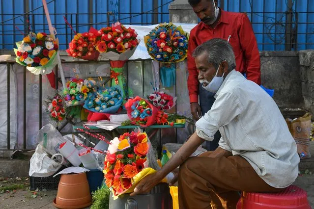A florist prepares flower bouquets in Bangalore on February 12, 2022, ahead of Valentines Day celebrations. (Photo by Manjunath Kiran/AFP Photo)